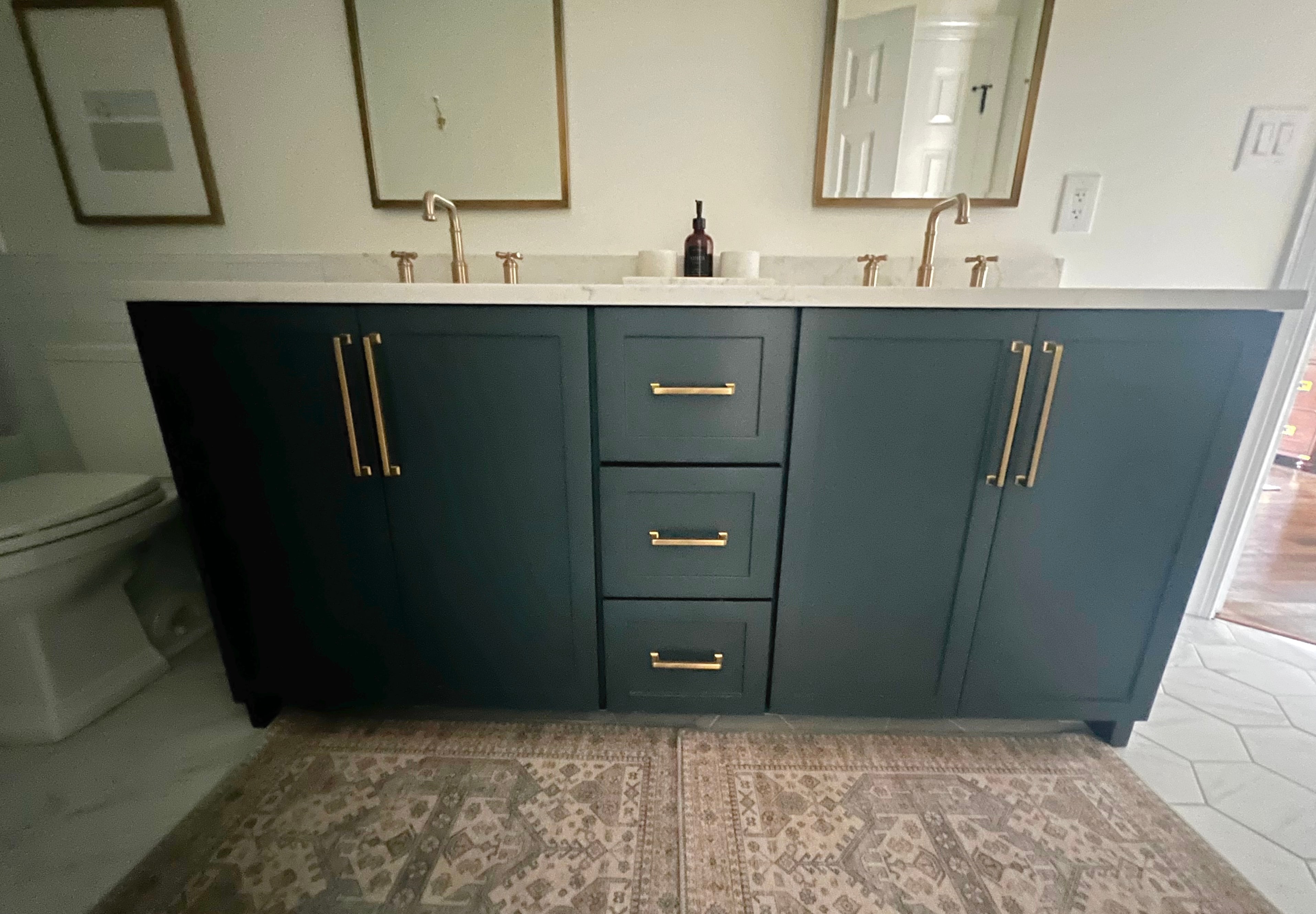 Double sink bathroom with teal vanity cabinets
